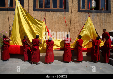 Mönche, die rollende Uo eine riesige Thanka, Indien, Ladakh Stockfoto