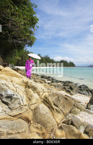 Frau zu Fuß auf felsigen Strand auf Pulau Manukan, Tunku Abdul Rahman Nationalpark, Kota Kinabalu, Sabah, Malaysia Borneo Stockfoto