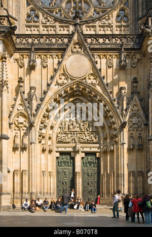 Vertikale Nahaufnahme von den Haupteingang St. Vitus Kathedrale mit Touristen in der Sonne auf der Treppe draußen sitzen. Stockfoto