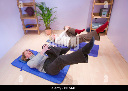 Frauen, die Pilates-Übung zur Steigerung der Flexibilität und Rumpfstabilität Stockfoto