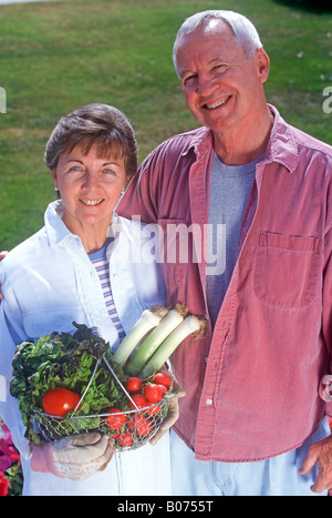 Mann und Frau halten frisches Gemüse im Korb aus ihrer Familiengarten. Stockfoto