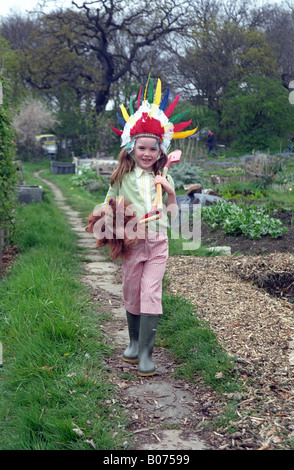 Kleines Mädchen in Kleingärten, Cowboys und Indianer zu spielen. Stockfoto