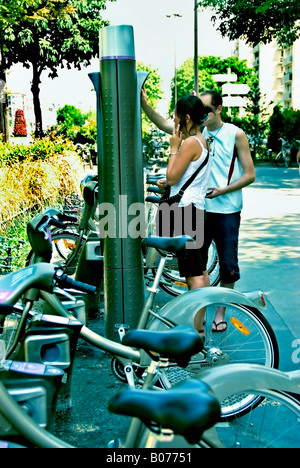 Paris Frankreich, junges Paar Touristen Teenager Sommer mieten Fahrrad Sharing Velib auf der Straße, Public Access Bike Scheme Docking Station Stockfoto