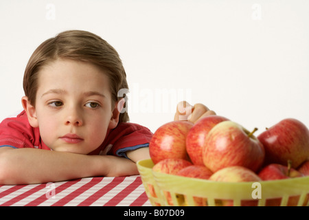 Junge sitzt neben ein paar Äpfel Stockfoto