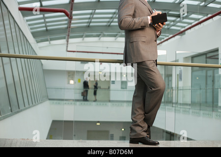 Geschäftsmann, Notizen in einem Bürogebäude Stockfoto