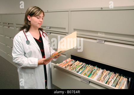 Arzt, Krankenschwester oder medizinische Sekretärin oder Überprüfung eine vertrauliche Patientenakte oder Labor-Ergebnisse in einer CAB-Datei-Schublade Stockfoto