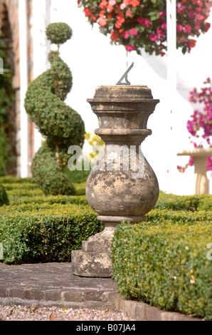 EINE SONNENUHR, UMGEBEN VON FELD ABSICHERUNG IN A WESTLICH VON ENGLAND GARTEN UK Stockfoto