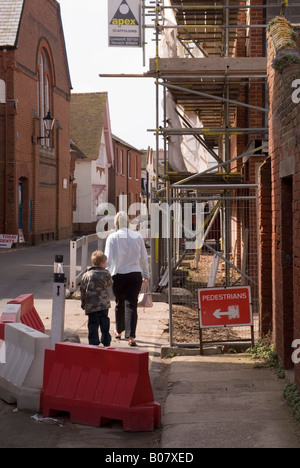 Fußgänger zu Fuß vorbei an einigen Gerüste in einer uk-Straße Stockfoto