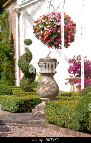 EINE SONNENUHR, UMGEBEN VON FELD ABSICHERUNG IN A WESTLICH VON ENGLAND GARTEN UK Stockfoto