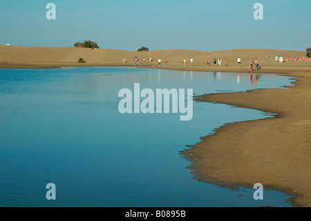 Menschen spazieren entlang der Oase der Sanddünen von Maspalomas an der Südküste der Insel Gran Canaria, einer der Kanarischen Inseln Spaniens Stockfoto