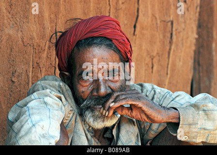 Alter Mann, der bidi raucht, eine indische Zigarette aus Tabakblättern oder Beedi-Blättern. Thakkar-Stamm. Ländliche Gesichter Indiens Stockfoto