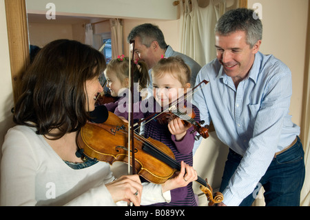 Mutter, kleine Tochter einer Geigenunterricht als Vater Uhren Stockfoto