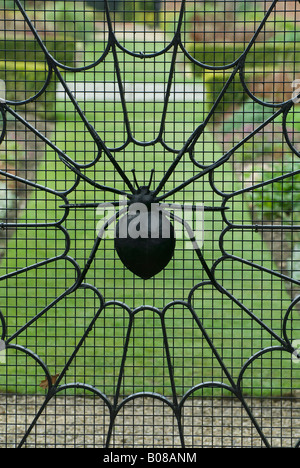 Spinnen-Netz auf schmiedeeisernen Tor im Garten Stockfoto