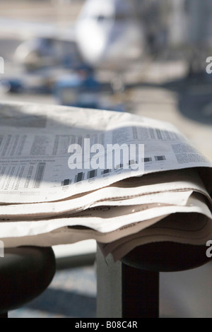 Zeitung auf Stuhl im Wartebereich des Flughafens gefaltet Stockfoto