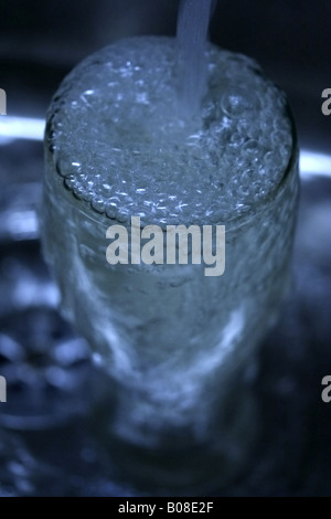 Eine vertikale Aufnahme eines Glases mit Wasser auffüllen. Stockfoto