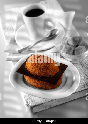 Eine handgemachte Patisserie Spezialität reichen verwöhnenden Schokoladenkuchen mit Kaffee in einem weißen Setting Stockfoto