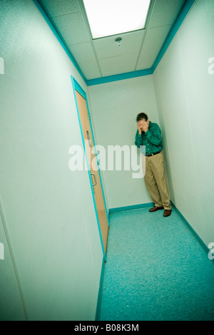 Man lehnte sich gegen die Wand am Ende eines langen Flurs Modell und Eigentum veröffentlicht Stockfoto