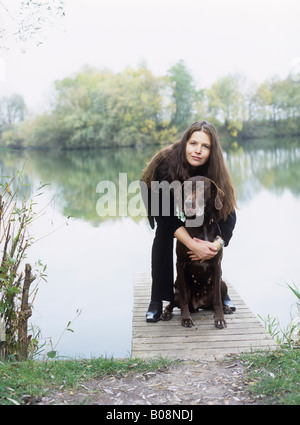 Frau und Hund steht auf einem Dock von einem See, Bayern, Deutschland Stockfoto