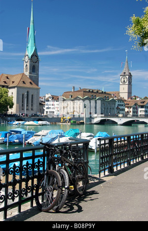 Blick über die Limmat Fraumünster und St. Peter Church, mit Fahrrädern auf einem Geländer im Vordergrund, der Schweiz, Zürich Stockfoto