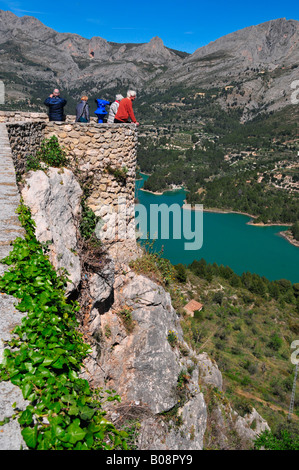 Touristen genießen den Blick auf Berge und Reservoir Damm vom Castell de Guadalest, Guadalest, Costa Blanca, Spanien Stockfoto