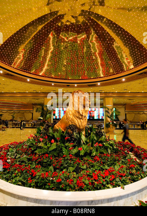 Statue eines goldenen Löwen, umgeben von roten Blumen unter einer goldenen Kuppel in der Lobby des MGM Grand Hotel and Casino, Las Vegas Stockfoto