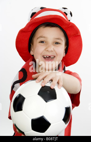 Junge als österreichische Fußball-Fan, mit Fußball und lustigen Hut Stockfoto