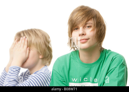 10 und 13 Jahre alten Jungen, 10-Year-Old bedeckte sein Gesicht mit den Händen Stockfoto