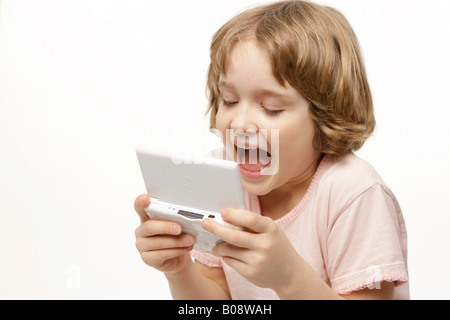 8 Jahre altes Mädchen spielen Game Boy Stockfoto