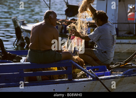 Zwei Fischer mit ihren Fischernetzen im Hafen von Agios Georgios auf der Akamas-Halbinsel, Zypern Stockfoto