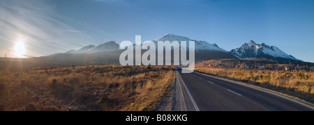 Panorama-Aufnahme einer geraden Straße führt zu Tatranská Lomnica und den Karpaten, hohe Tatra Gipfel (zurück) in der Nähe von Vysok Stockfoto