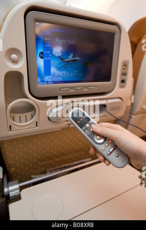 Mithilfe der Fernbedienung bedienbar Economy-Class Unterhaltungsprogramm an Bord eines Singapore Airlines Boeing 777 Stockfoto