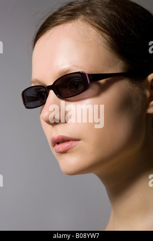 Junge dunkelhaarige Frau mit Sonnenbrille Stockfoto