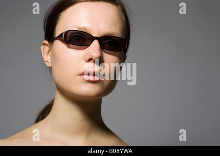 Junge dunkelhaarige Frau mit Sonnenbrille Stockfoto