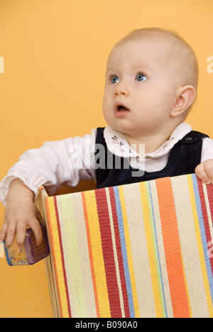 Baby mit Rassel in einer box Stockfoto