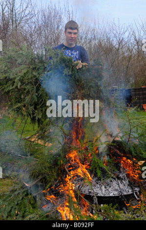 Teenager verbrennen von Gartenabfällen in einem Hof Stockfoto