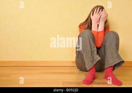 Mädchen sitzt in ihrem Zimmer, traurig, wütend Stockfoto