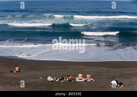 Sonnenanbeter und Surfer am Strand Playa del Socorro auf der Nordseite von Teneriffa, Kanarische Inseln, Spanien Stockfoto