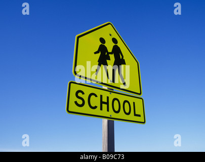 Eine Schule auf einer Autobahn Hinweises Besucher zu stoppen und nachgeben, Kinder beim Überqueren der Straße Stockfoto