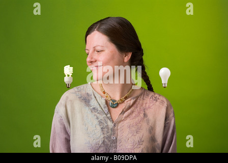 ein Umweltschützer schaut zustimmend eine kompakte Leuchtstoff Glühlampe Stockfoto