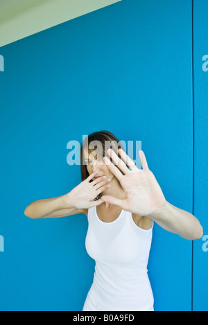 Frau Hand in Hand vor der Gesicht, Blick in die Kamera Stockfoto