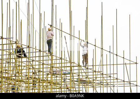 Arbeiter bauen Gerüste auf Baustelle Stockfoto