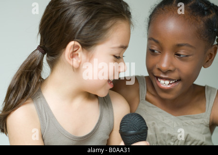 Zwei kleine Mädchen singen in Mikrofon, Nahaufnahme Stockfoto