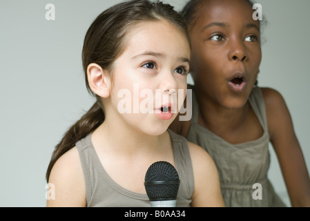 Zwei kleine Mädchen singen in Mikrofon zusammen, Nahaufnahme Stockfoto