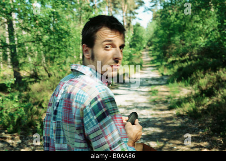 Mann zu Fuß auf Weg im Wald, auf der Suche über die Schulter in die Kamera, Nahaufnahme Stockfoto