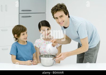 Kochen mit Mädchen und jungen, lächelnd in die Kamera Mann Stockfoto