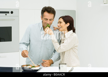 Mann, Kochen, Frau hält Basilikum für Mann zu riechen Stockfoto