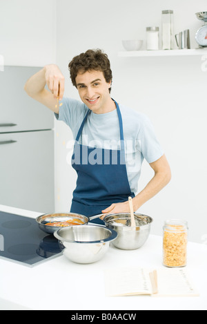 Junger Mann kochen, lächelnd in die Kamera Stockfoto