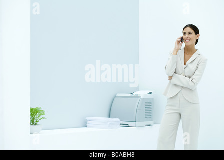 Junge Geschäftsfrau mit Handy im Büro, Lächeln Stockfoto