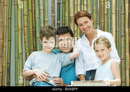 Familie lächelnd zusammen vor Bambus, Gruppenbild Stockfoto