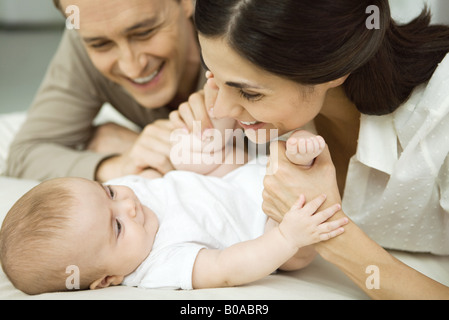 Neue Eltern, Kleinkind, lächelte Mutter halten Babys Beine, Nahaufnahme Stockfoto
